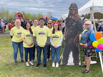 Group of People Standing Next to Chewbacca Cutout