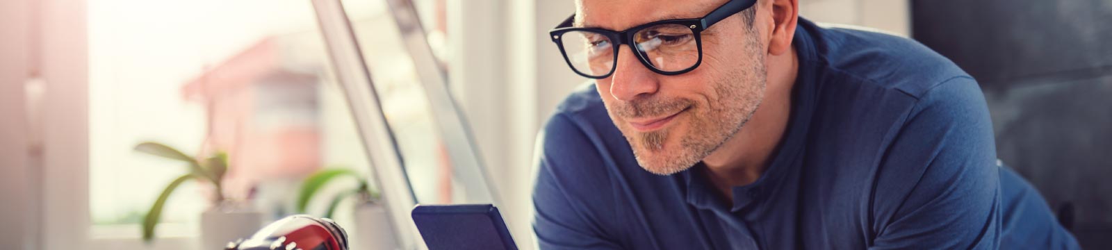 Man Wearing Glasses Looking at His Phone