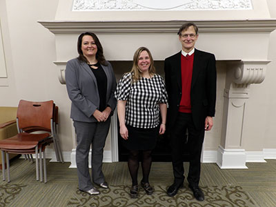 Desiree, Megan and John Standing in Front of Fireplace