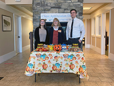 Emily, Carol, Philip Standing Behind Treats Table