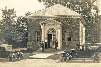Old Stone Bank with People Standing out Front