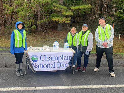 Four People Standing Near Table with Cups of Water On It