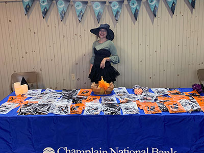 Kurri standing in front of a table of bags of candy