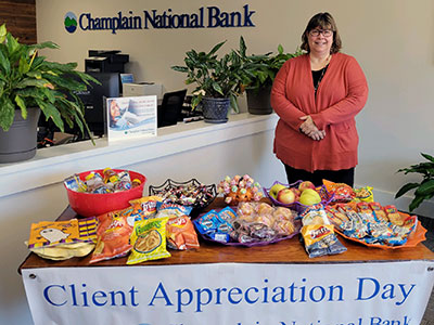 Saranac Lake Employee Standing Next to Halloween Table of Treats